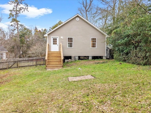 rear view of house with a yard and fence