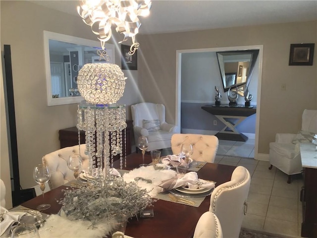 dining area with baseboards, tile patterned flooring, and an inviting chandelier