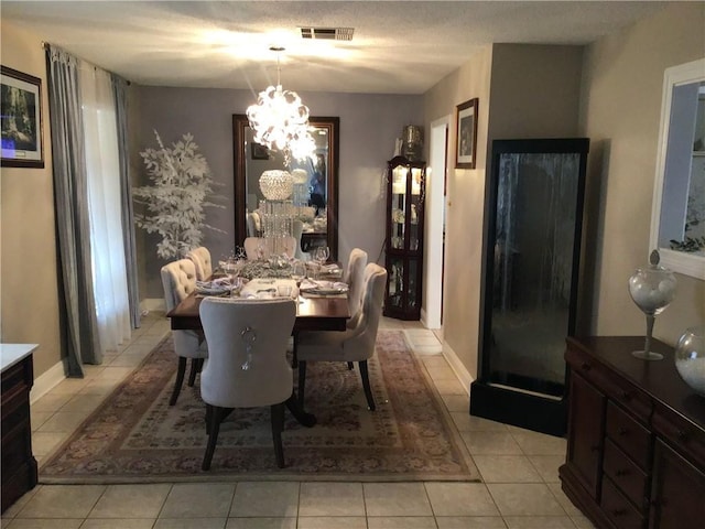 dining area featuring an inviting chandelier, baseboards, light tile patterned floors, and visible vents