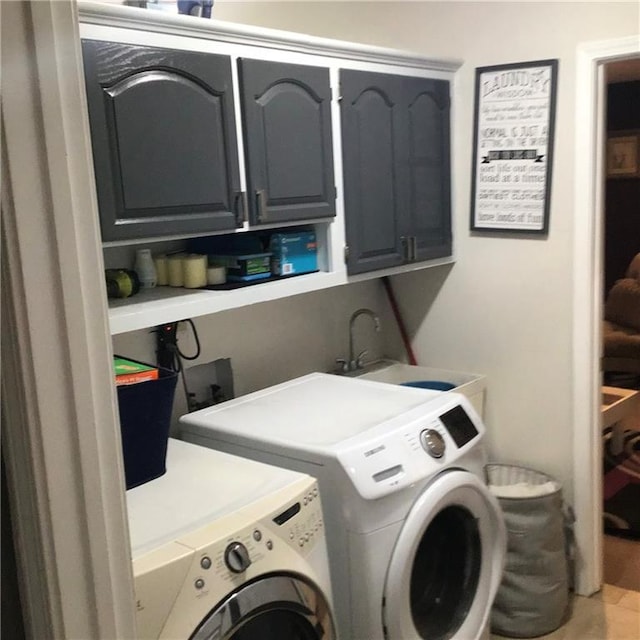 laundry room with cabinet space, a sink, and independent washer and dryer