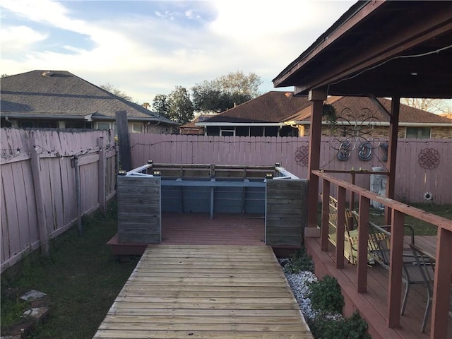 wooden terrace with a fenced backyard