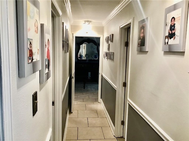 hallway with light tile patterned floors and crown molding