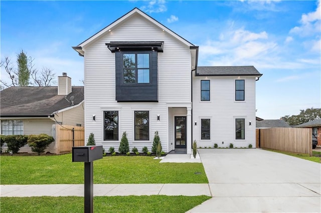 view of front of house with fence and a front lawn