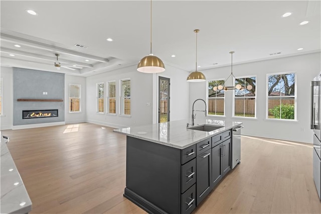 kitchen featuring light wood-type flooring, a fireplace, a sink, and recessed lighting