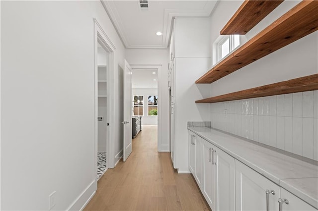 corridor featuring crown molding, recessed lighting, visible vents, light wood-style flooring, and baseboards