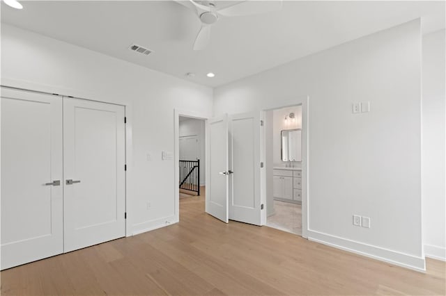 unfurnished bedroom featuring visible vents, a closet, light wood-style flooring, and baseboards