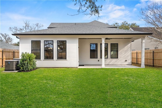 rear view of house with ceiling fan, cooling unit, fence, a lawn, and a patio area