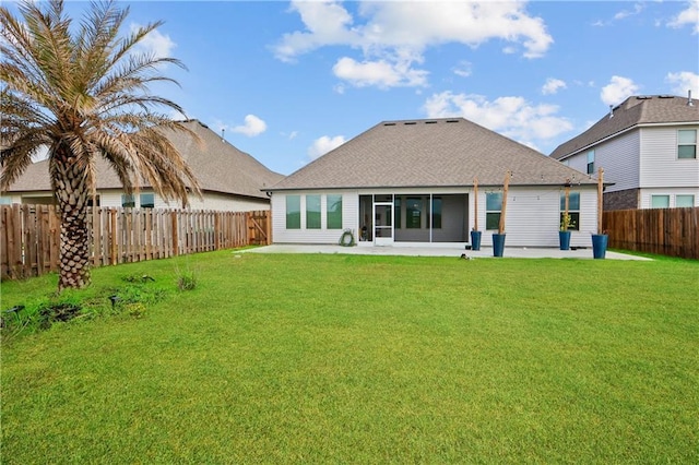 rear view of property featuring a patio, a lawn, a fenced backyard, and roof with shingles