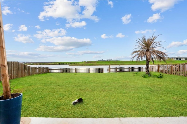 view of yard featuring a water view and a fenced backyard