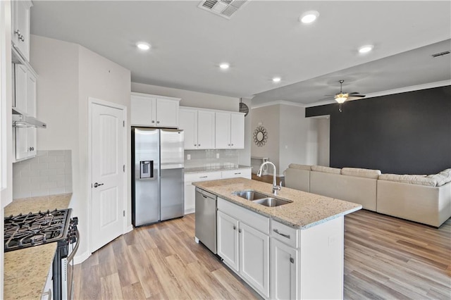 kitchen with appliances with stainless steel finishes, light wood-type flooring, visible vents, and a sink