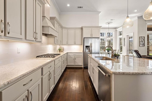 kitchen with ornamental molding, appliances with stainless steel finishes, a sink, and custom range hood