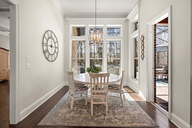 dining area featuring a chandelier, ornamental molding, dark wood-type flooring, and baseboards