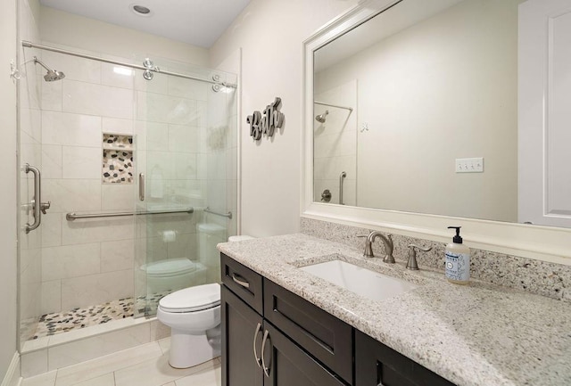 bathroom featuring toilet, a shower stall, and vanity