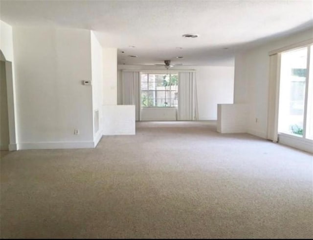 spare room with light carpet, baseboards, and a ceiling fan