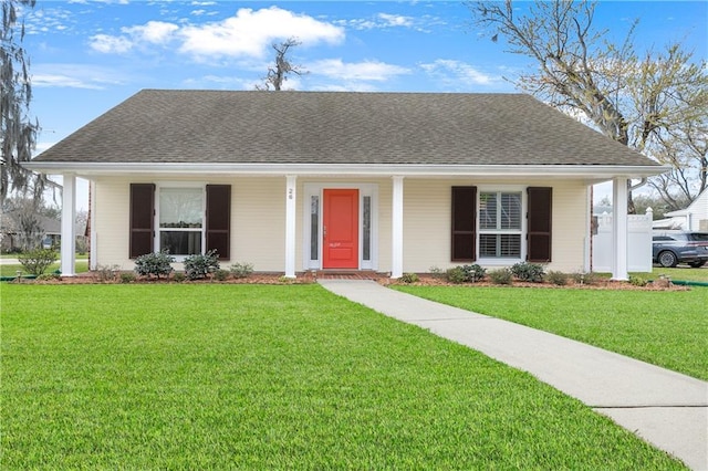 single story home with covered porch, a shingled roof, and a front yard