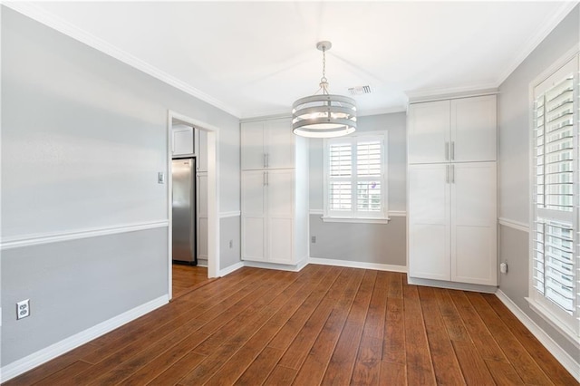 unfurnished dining area featuring dark wood-style floors, a notable chandelier, visible vents, and crown molding