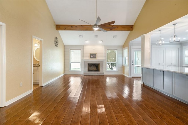 unfurnished living room with a brick fireplace, a ceiling fan, dark wood-style flooring, and ornate columns