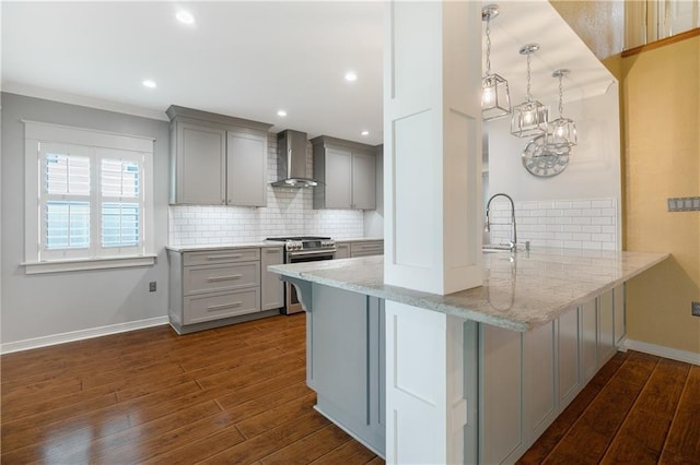 kitchen with wall chimney exhaust hood, high end stainless steel range oven, a peninsula, and gray cabinetry