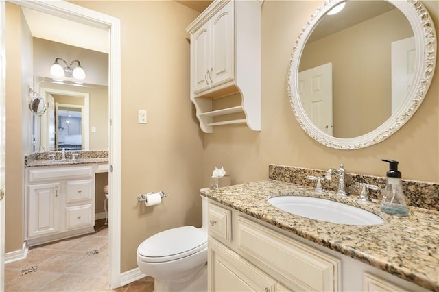 bathroom with baseboards, vanity, toilet, and tile patterned floors