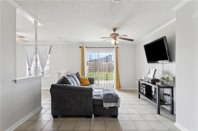 living area with a ceiling fan, light tile patterned flooring, crown molding, and baseboards