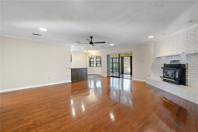 unfurnished living room with crown molding, a textured ceiling, and hardwood / wood-style floors