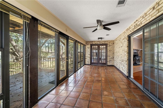 unfurnished sunroom with french doors, visible vents, and ceiling fan