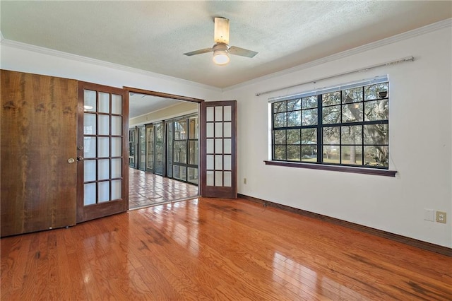 empty room featuring ornamental molding, a textured ceiling, and hardwood / wood-style floors