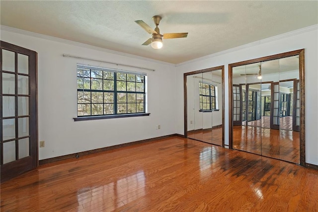 empty room with hardwood / wood-style flooring, a textured ceiling, and crown molding