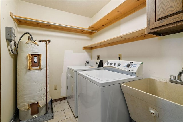 washroom with cabinet space, light tile patterned floors, separate washer and dryer, and a sink