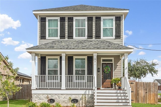 view of front of home featuring covered porch, roof with shingles, and fence