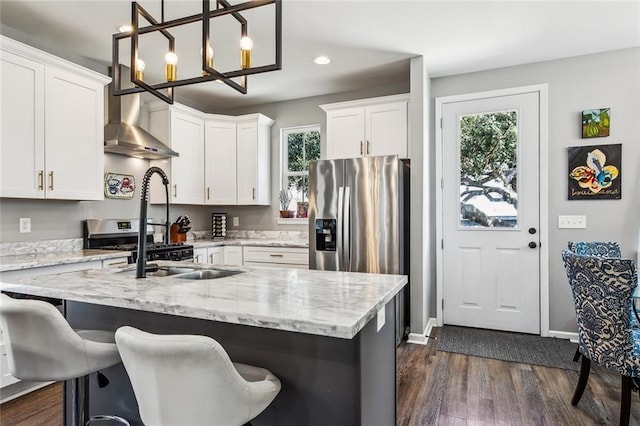 kitchen featuring wall chimney range hood, dark wood-style flooring, a wealth of natural light, and white cabinets