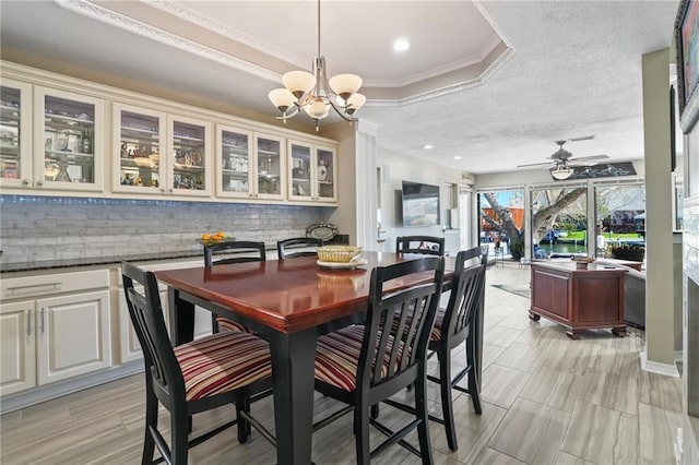 dining area featuring recessed lighting, a raised ceiling, ornamental molding, a textured ceiling, and ceiling fan with notable chandelier