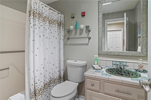 full bath with curtained shower, vanity, and toilet