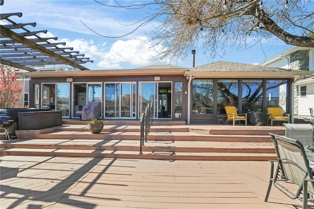 deck with a sunroom and a pergola