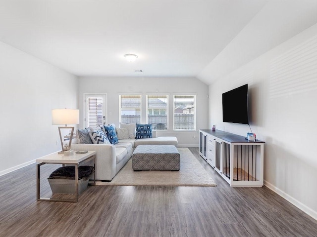 living area featuring visible vents, baseboards, vaulted ceiling, and wood finished floors