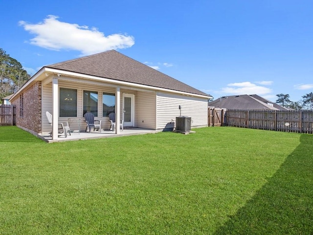 rear view of property featuring a patio area, a lawn, and a fenced backyard