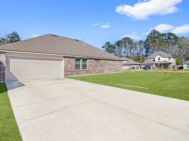 view of front of home with driveway, a garage, a front yard, and brick siding