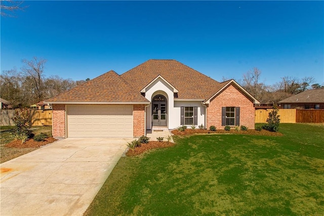 ranch-style house with brick siding, an attached garage, fence, driveway, and a front lawn