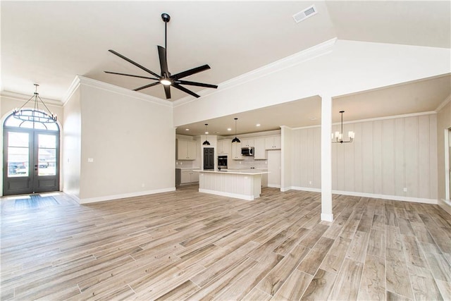 unfurnished living room with baseboards, visible vents, light wood-style flooring, crown molding, and ceiling fan with notable chandelier