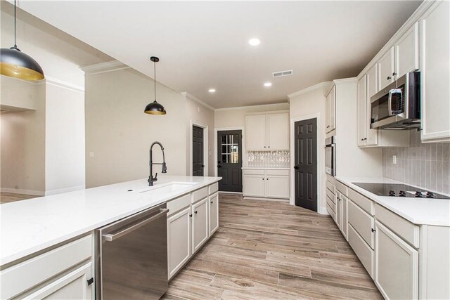 kitchen featuring visible vents, stainless steel appliances, light countertops, light wood-style floors, and a sink