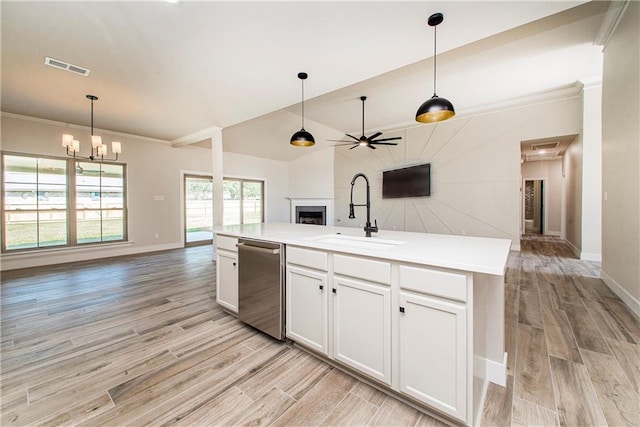 kitchen featuring a fireplace, stainless steel dishwasher, open floor plan, a sink, and light wood-type flooring