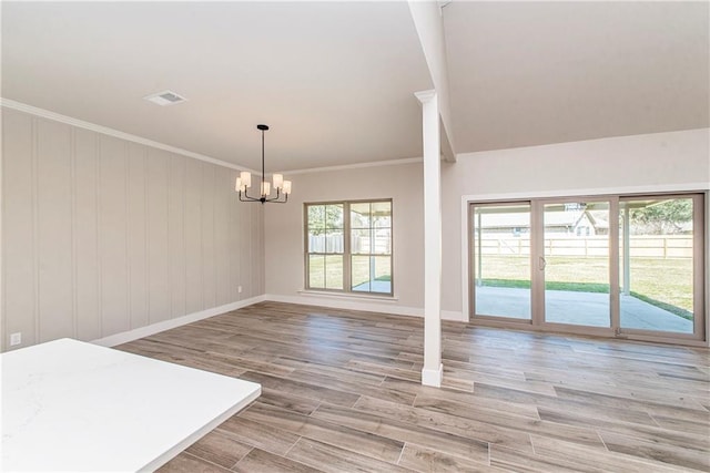 unfurnished dining area with light wood-style flooring, a notable chandelier, visible vents, baseboards, and ornamental molding