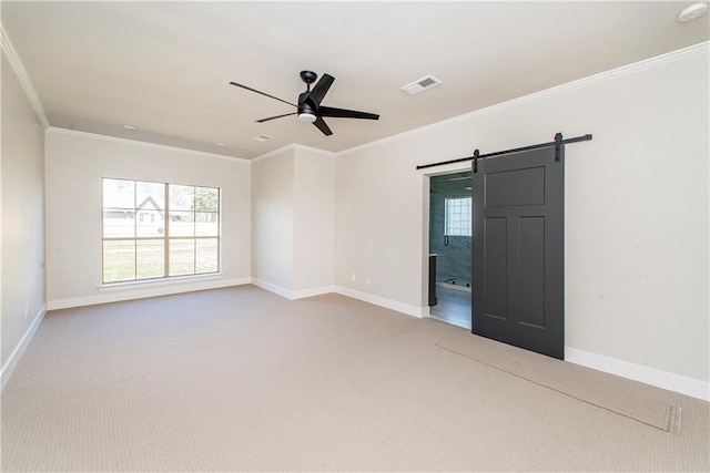 carpeted spare room featuring ornamental molding, a healthy amount of sunlight, visible vents, and a barn door