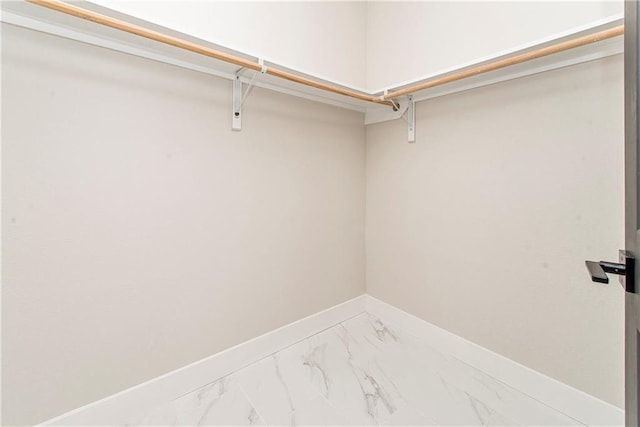 spacious closet featuring marble finish floor