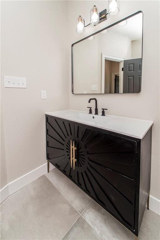 bathroom featuring vanity, baseboards, and tile patterned floors