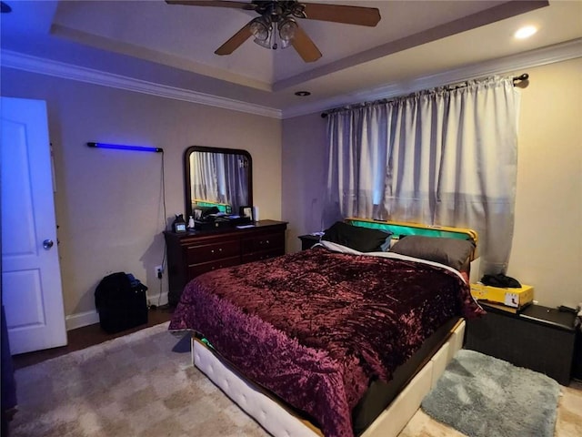 bedroom featuring baseboards, a tray ceiling, a ceiling fan, and ornamental molding