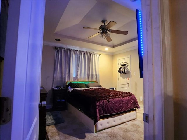 bedroom featuring ceiling fan, ornamental molding, and a raised ceiling