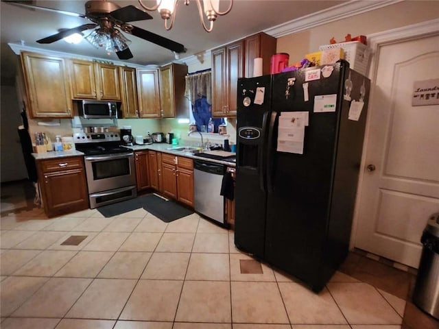 kitchen with appliances with stainless steel finishes, light countertops, a sink, and ornamental molding