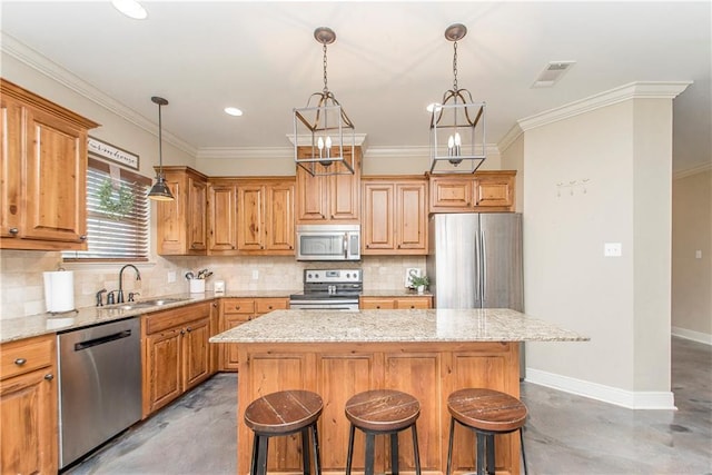 kitchen featuring light stone counters, stainless steel appliances, a kitchen island, a sink, and baseboards