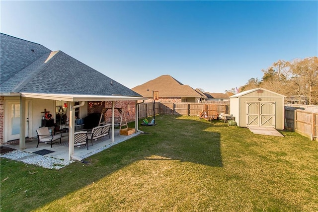 view of yard with a storage unit, a patio area, a fenced backyard, and an outdoor structure